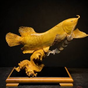 Golden Arowana sculpture displayed on a dark base