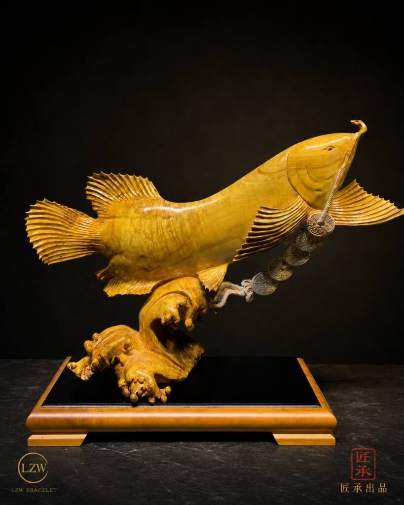 Golden Arowana sculpture displayed on a dark base