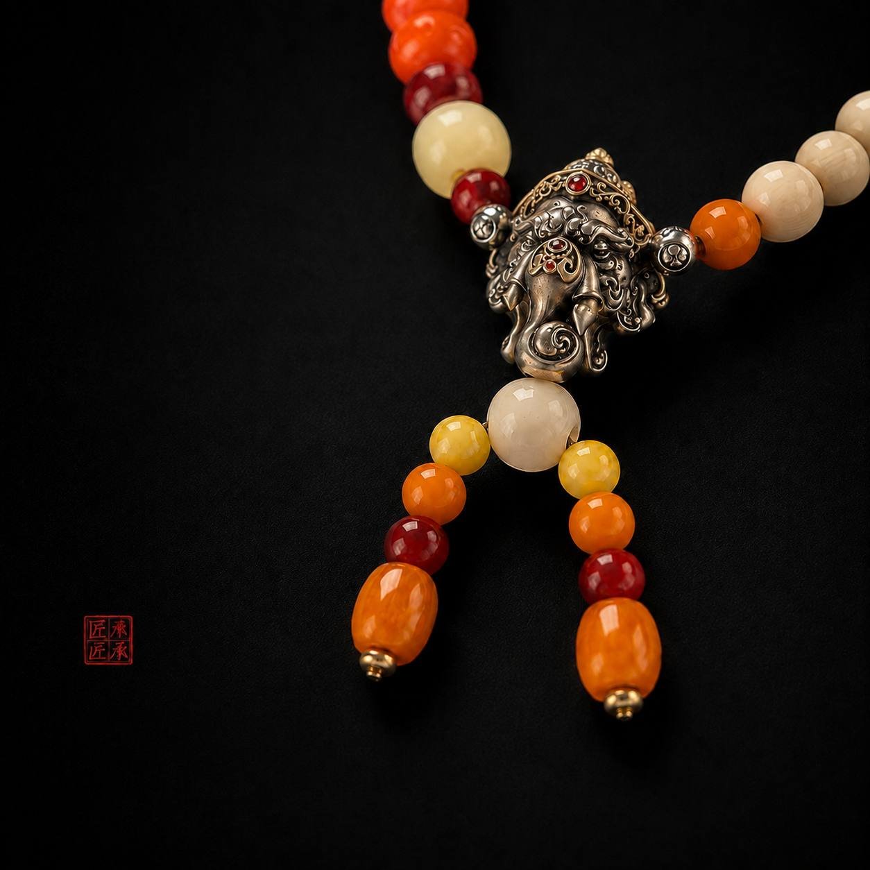 Close-up of sculptural Tingdi pendant and tassel bead drops