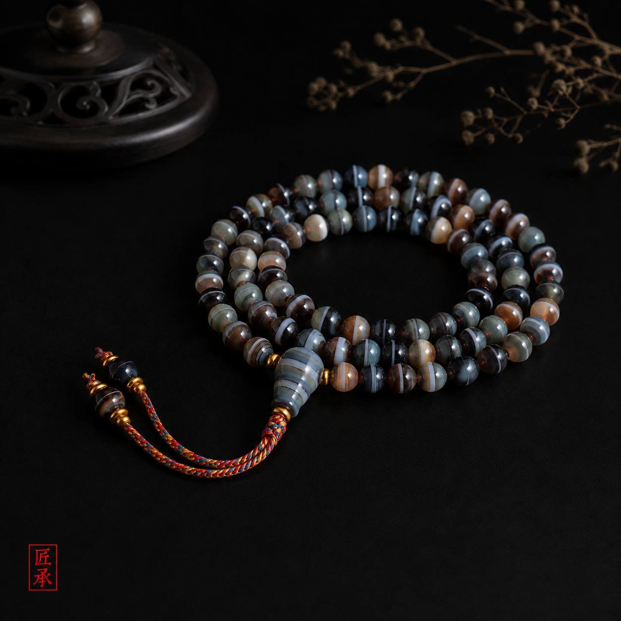 SHADOWED TIDES banded agate 108-bead mala displayed on a dark surface