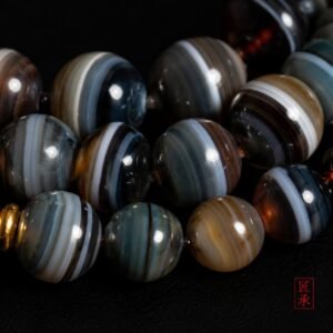 Macro view of layered banded agate beads on SHADOWED TIDES 108-bead mala