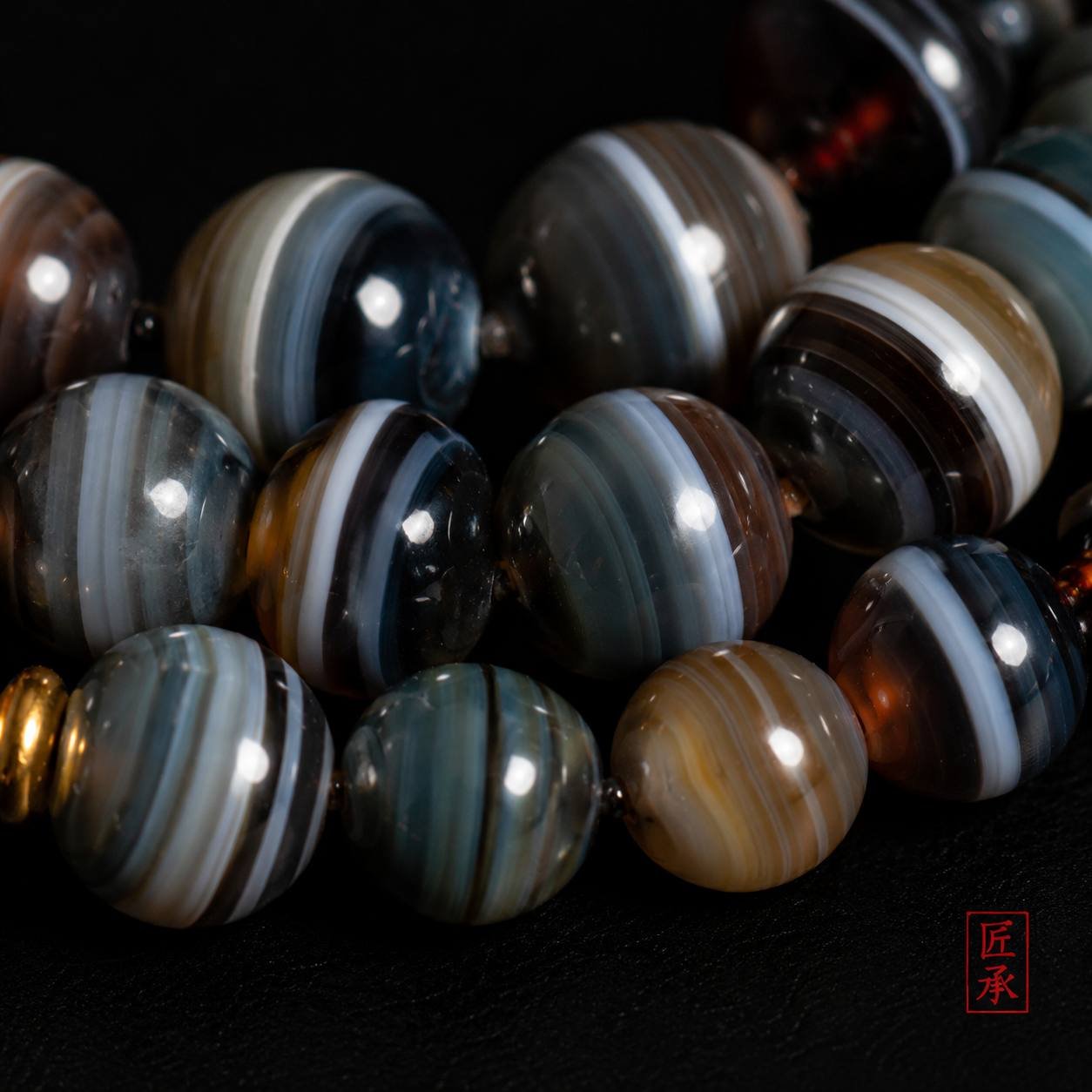 Macro view of layered banded agate beads on SHADOWED TIDES 108-bead mala