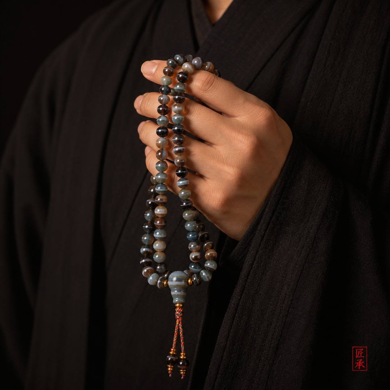 SHADOWED TIDES banded agate 108-bead mala held in the hand