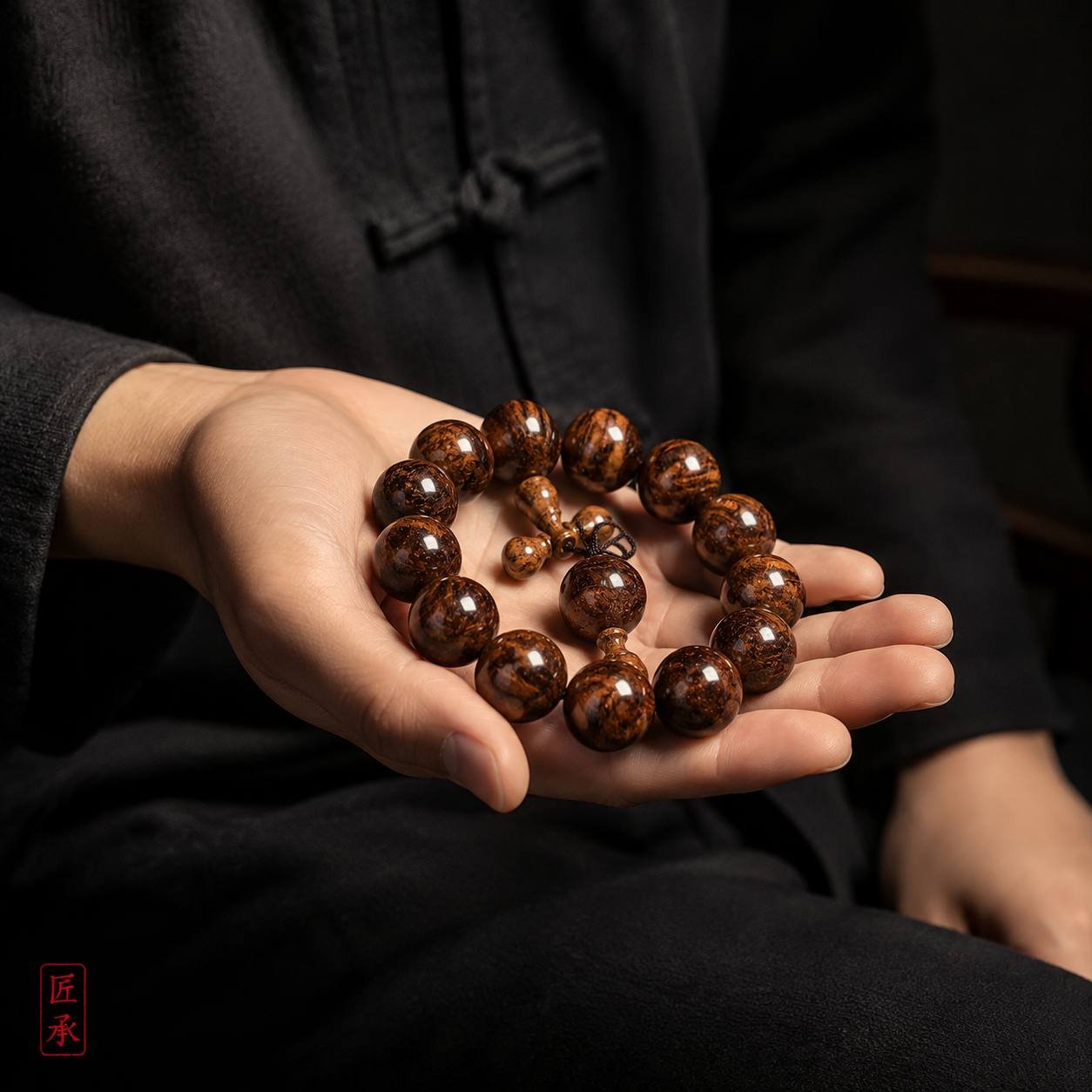 EMBER FLOW Huanghuali wood bead bracelet held in the hand