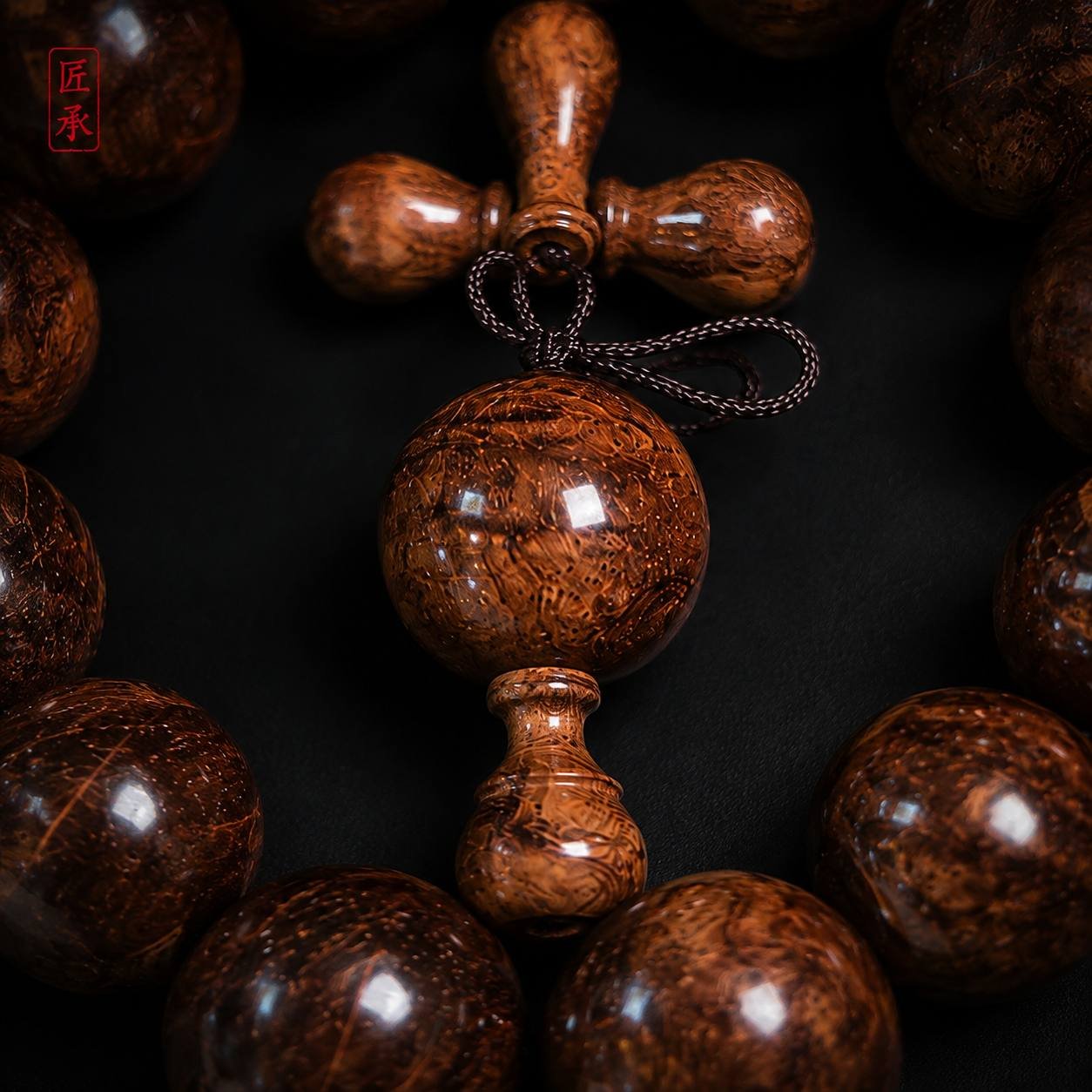 Close-up of EMBER FLOW Huanghuali wood focal bead and carved details