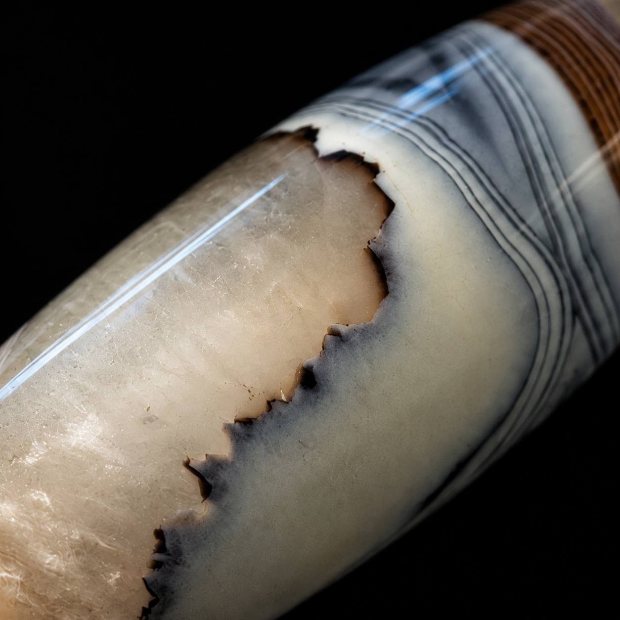 Macro view of CLOUD VEIL agate barrel bead with layered natural bands