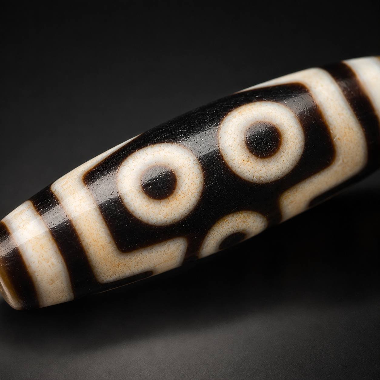 Macro view of TWIN GAZE two-eye motif on a Dzi bead