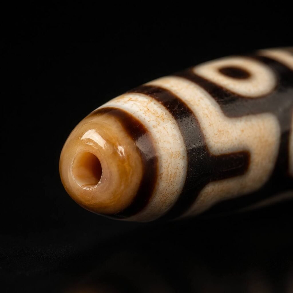 Close-up of TWIN GAZE Dzi bead drilled end and geometric pattern