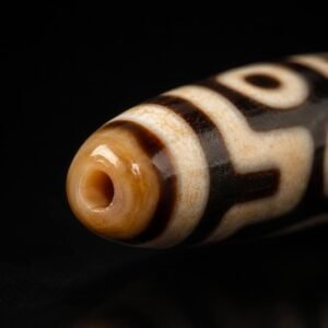 Close-up of TWIN GAZE Dzi bead drilled end and geometric pattern