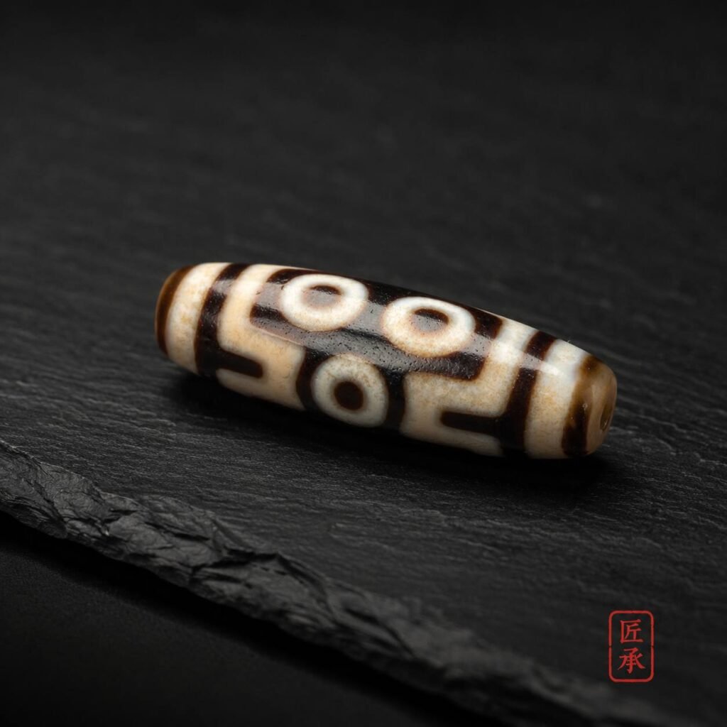 TWIN GAZE two-eye Dzi bead displayed on dark slate