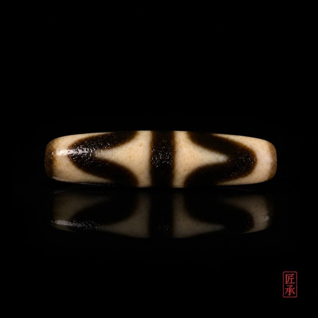 Front view of Tiger Tooth Dzi bead with black and ivory pattern