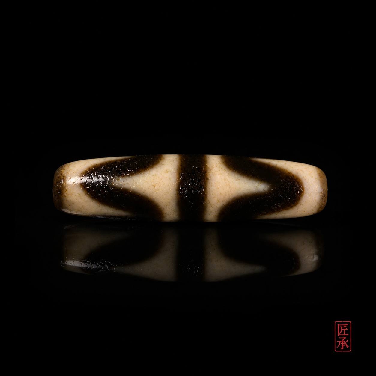 Front view of Tiger Tooth Dzi bead with black and ivory pattern
