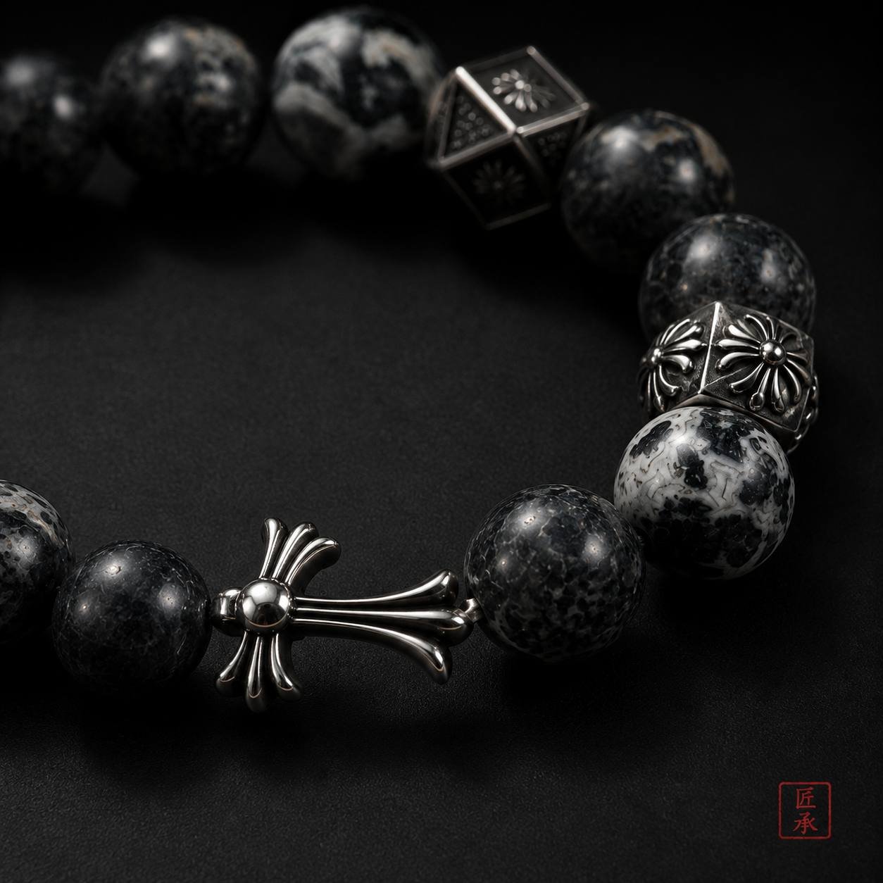 Close-up of black obsidian beads and cross-shaped focal accent