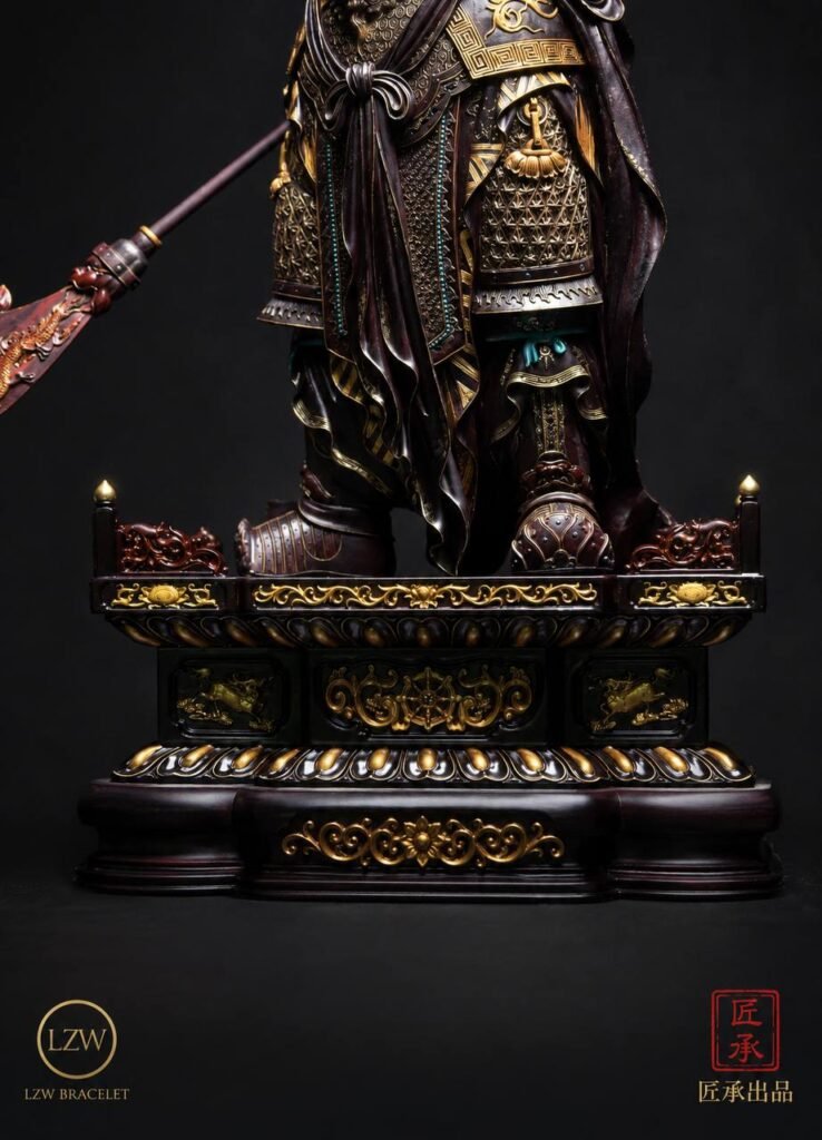 Guan Yu warrior statue with gilded armor on a traditional base