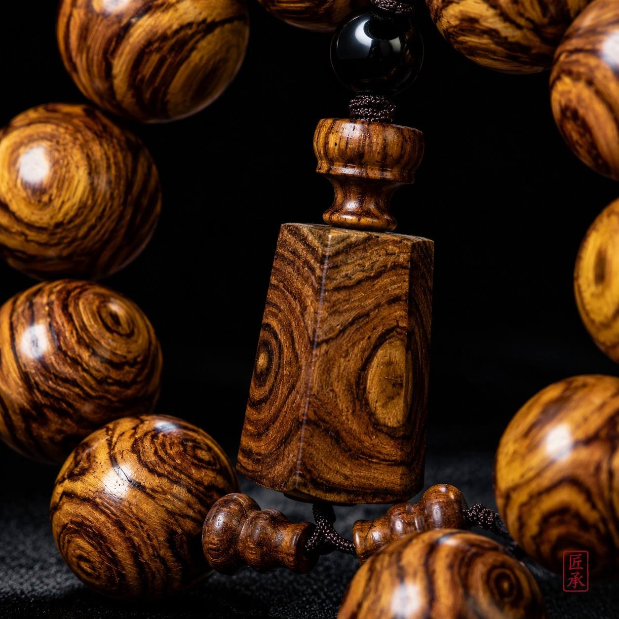 Close-up of central pendant plaque on GILDED GRAIN Huanghuali bead bracelet