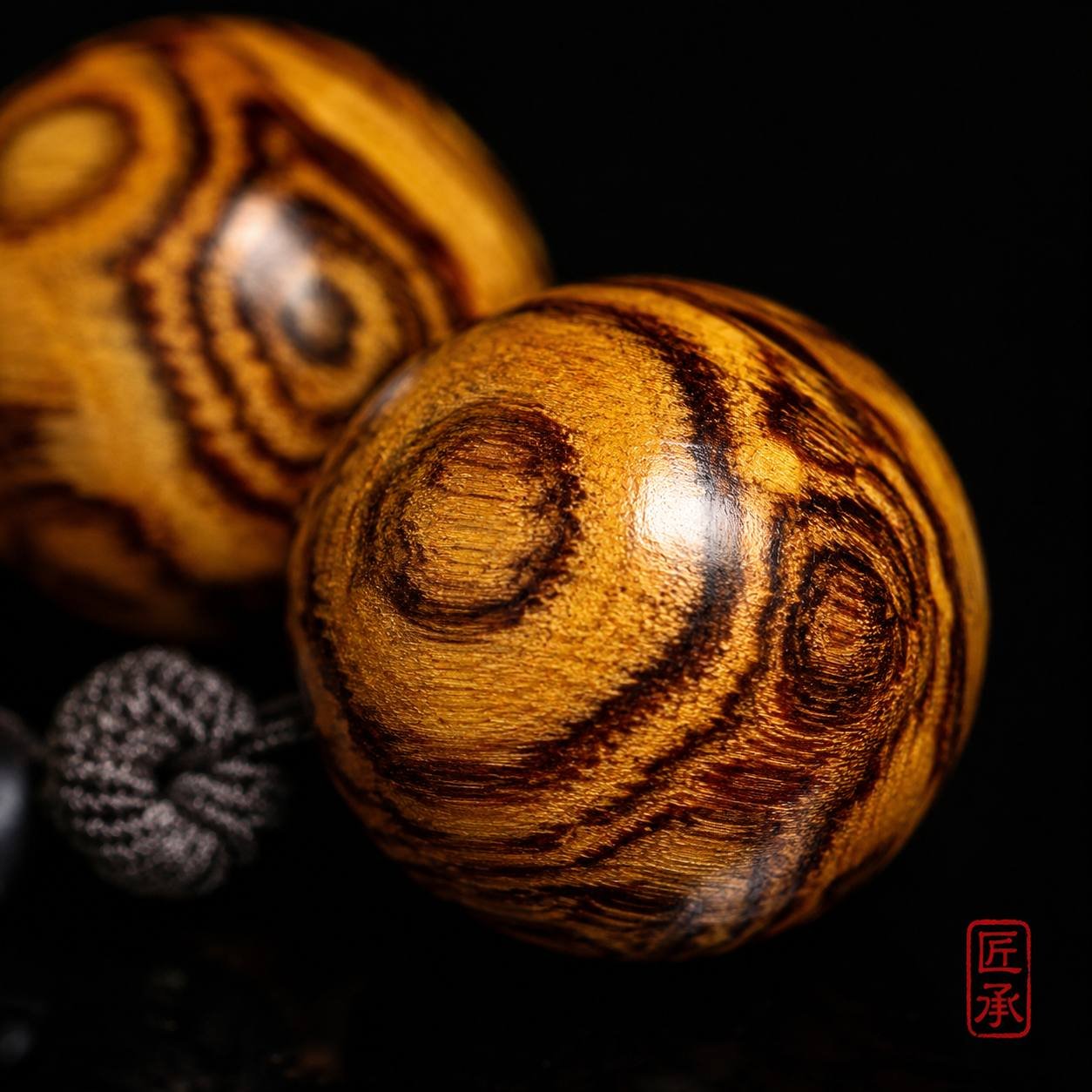 Macro view of 18 mm Huanghuali wood bead grain on GILDED GRAIN bracelet