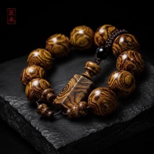 GILDED GRAIN Huanghuali bead bracelet displayed on a dark stone surface