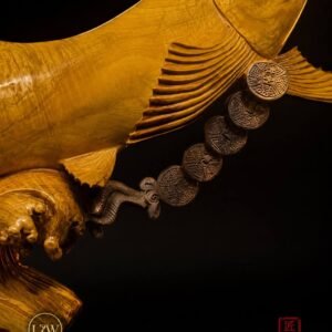 Close-up of Arowana sculpture and coin-style decorative detail