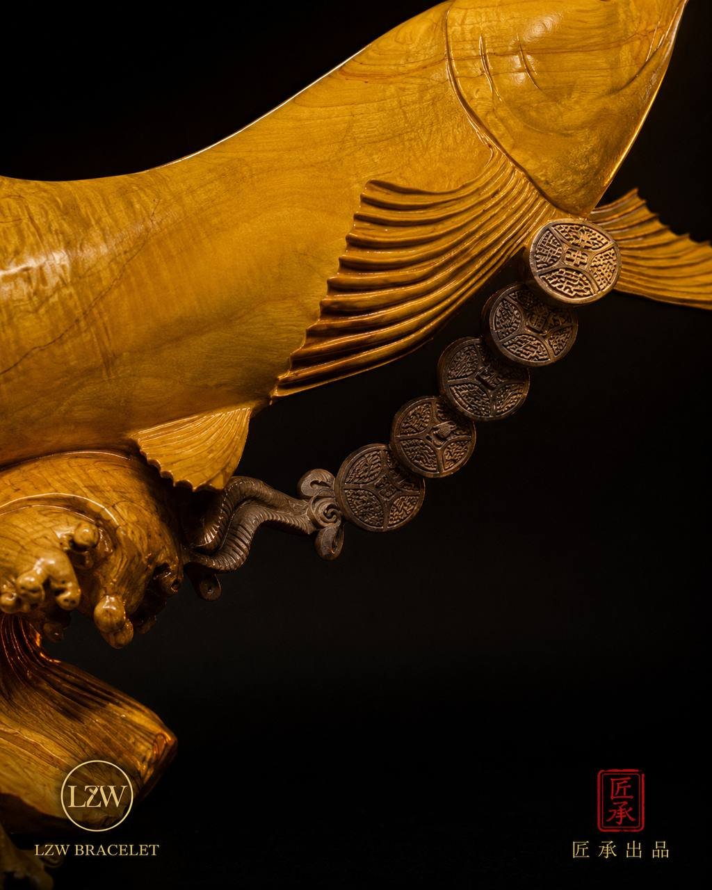 Close-up of Arowana sculpture and coin-style decorative detail